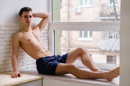 Young fit muscle man model posing at home kitchenの写真素材