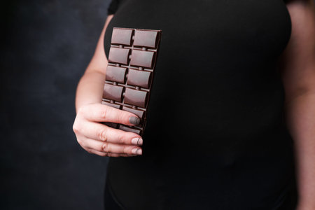 Overweight woman with chocolate bar.