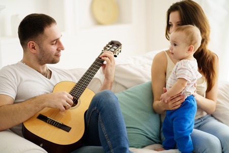 Father playing guitar for mother and son. leisureの写真素材