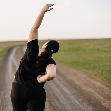 Young woman doing yoga exercises in the meadowの写真素材