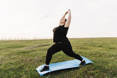 Young woman doing yoga exercises in the meadowの写真素材
