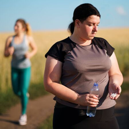 Overweight woman taking slimming pillsの写真素材
