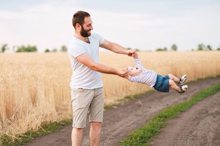 Dad playing with little baby son. Father and child walking outdoors. Childhood, parenthood, paternity, happy family conceptの写真素材