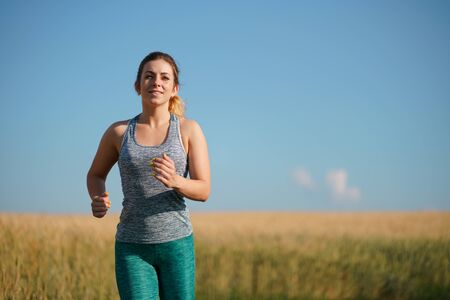 Woman jogger working out in the morning sunny dayの写真素材