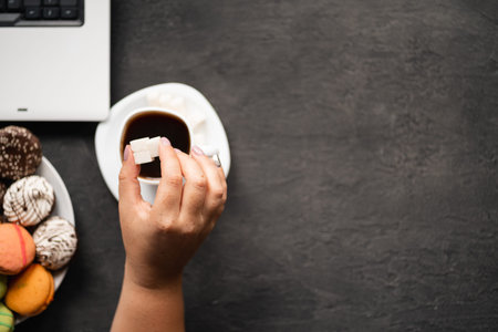Woman pouring huge amount of sugar into coffee