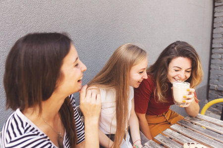 Three female friends having a great time at cafe