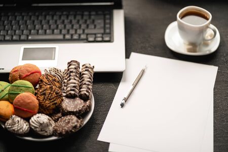 workplace with laptop computer, coffee and treatsの写真素材