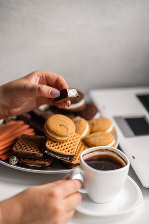 Woman snacking with sweets and junk foodの写真素材