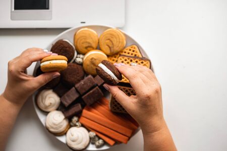 Woman snacking with sweets and junk foodの写真素材