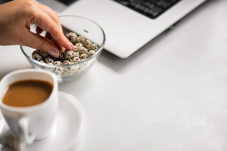 woman taking candy from glass bowl on a desktop