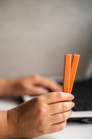 Woman eating cookies and coffee at workplace