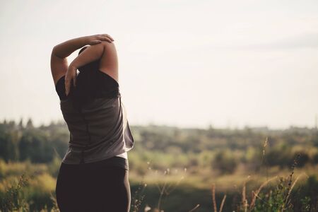 Overweight woman stretching hands during walkの写真素材