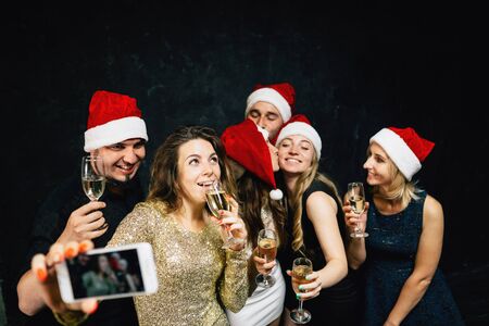 Happy friends having fun celebrating Christmasの写真素材