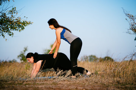 Personal trainer working with her client outdoorsの写真素材