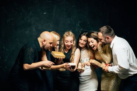 Friends exchanging and opening festive presentsの写真素材