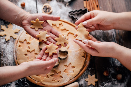 Friends cutting cookies of raw gingerbread dough