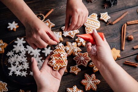 Friends decorating christmas gingerbread cookiesの写真素材