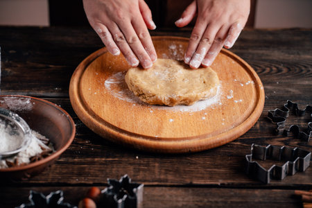 Woman kneading gingerbread dough on pastry board