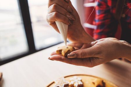 Woman decorating Christmas gingerbread cookiesの写真素材