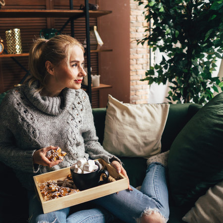 woman in knitted sweater with mug of hot chocolate