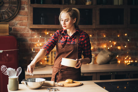 confectioner sprinkling flour on gingerbread doughの写真素材