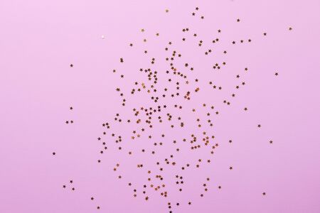 Pink background with gold star shaped confettiの写真素材