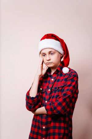 bored and pensive kid in christmas hatの写真素材