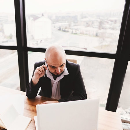 Young businessman talking on smartphone at office