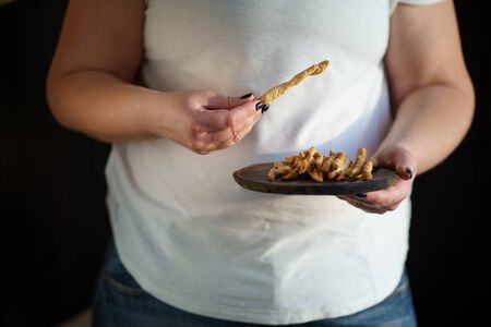 Overweight woman with plate of bread sticksの写真素材