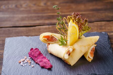 Delicious snack, pancakes with salmon on slateの写真素材