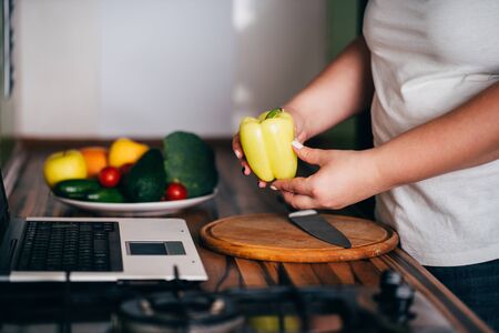Cooking recipe online culinary blog, weight loss support. Overweight woman recording video for vlog cooking healthy food at home kitchenの写真素材