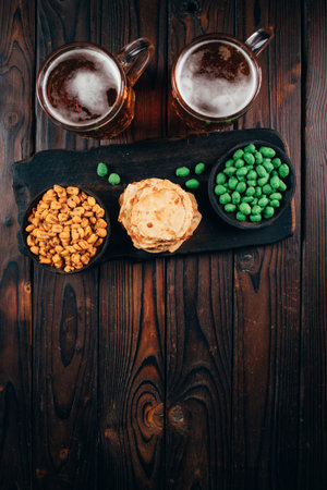 two mugs of lager and salty traditional appetizersの写真素材