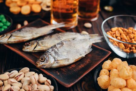 Pile of varied beer snacks on a wooden tableの写真素材