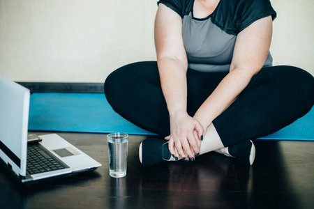 Overweight woman taking a break at home training