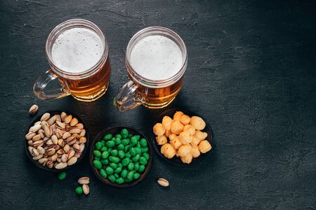 Nuts, pistachios and corn with two mugs of lagerの写真素材