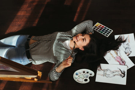 woman dreaming laying on the floor with sketches
