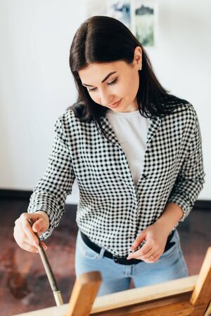Woman do easel drawing, holding brush in handの写真素材