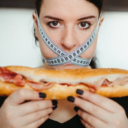 Obese woman with unhealthy food, eating disorderの写真素材