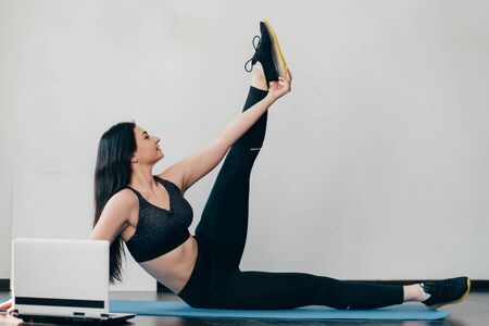 woman doing stretching exercise using online guideの写真素材