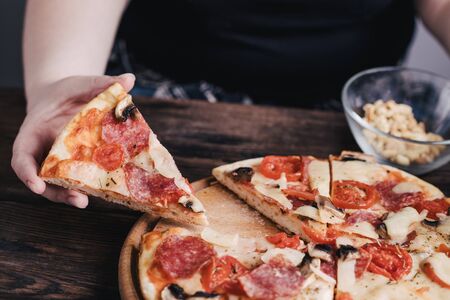 Overweight woman eating pizza. Food deliveryの写真素材