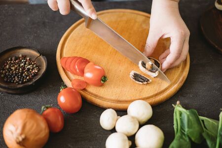 Diet concept, healthy lifestyle, low calorie food. Closeup portrait of woman cooking healthy dinner of vegetables and mushroomsの写真素材