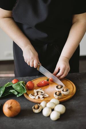 Closeup portrait of woman cooking healthy dinnerの写真素材