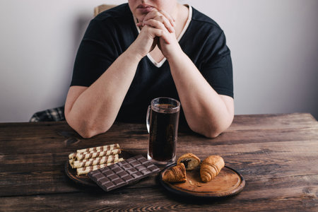 Overweight woman with big amount of sugary food