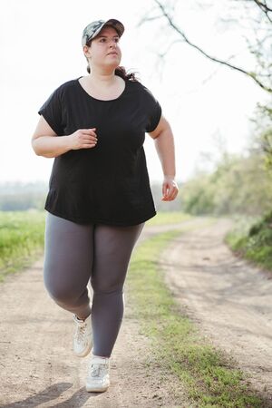 Cropped portrait of overweight runner go joggingの写真素材