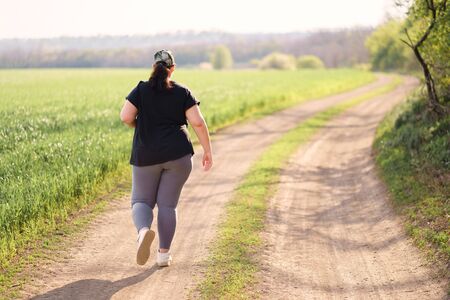 Overweight woman running in countrysideの写真素材