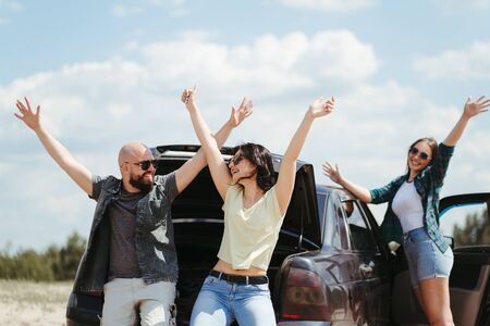 Three friends enjoying vacation travel by carの写真素材