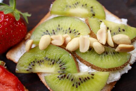 Sliced kiwi and strawberry on toasts, close upの写真素材