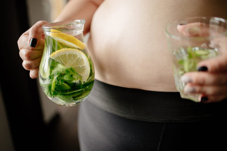 Overweight woman drinking infused water. Detox