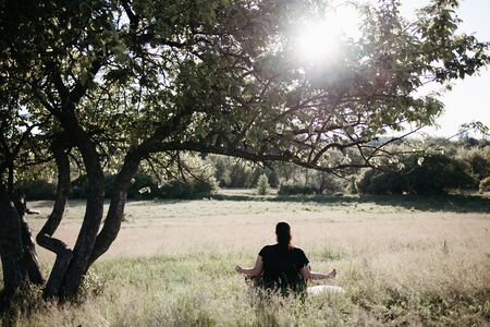 Overweight woman practicing yoga outdoorsの写真素材