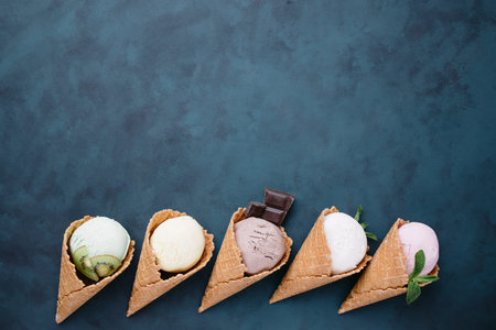 Ice cream background with cones on dark table